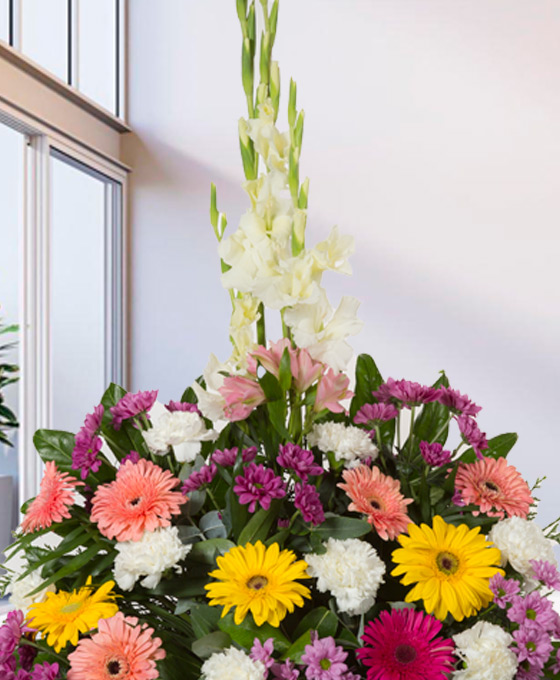 centro de flores para funeral con tonos variados